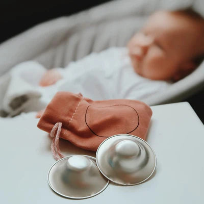 Seal SilverCups med oppbevaringspose, nyfødt baby i bakgrunnen